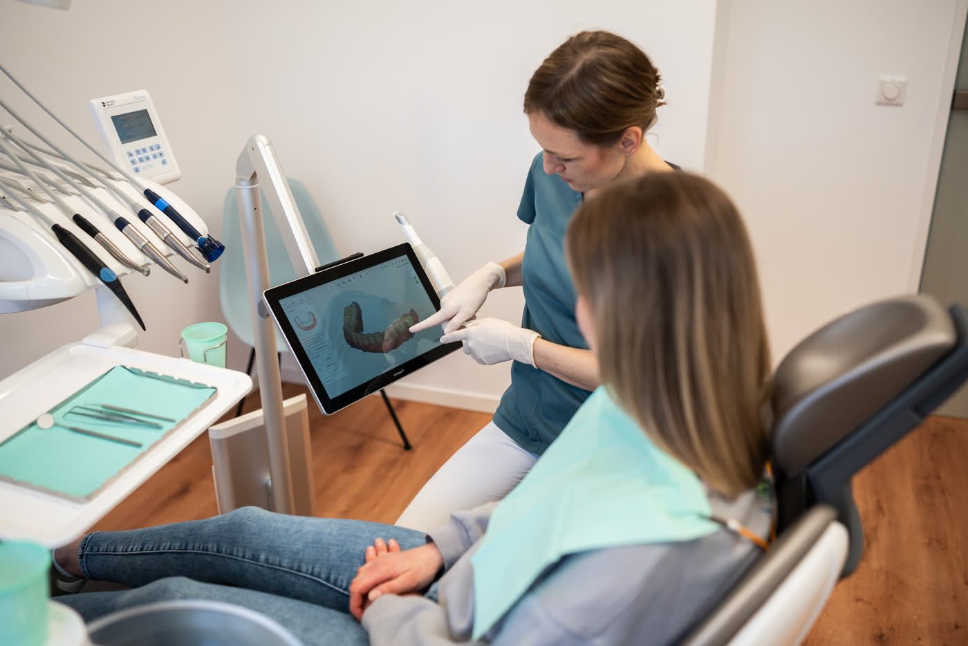 Eine Zahnärztin zeigt einer Patientin den 3D-Scan ihrer Zähne am Bildschirm